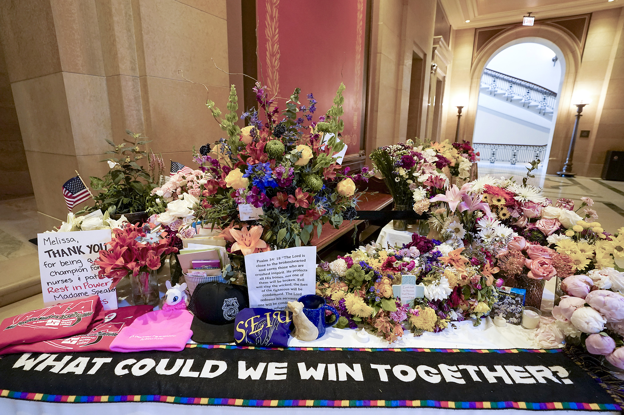 Flowers, pictures, notes and other items continue to be added to a makeshift memorial outside of the House Chamber in honor of Speaker Emerita Melissa Hortman. (Photo by Michele Jokinen)
